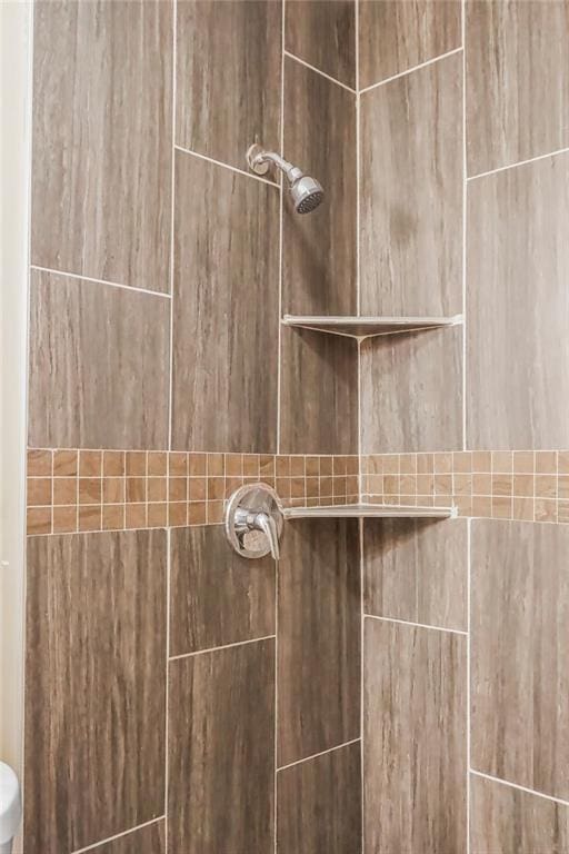 interior details featuring a tile shower