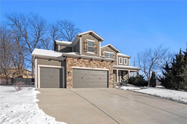 view of front of house featuring stone siding, fence, driveway, and stucco siding