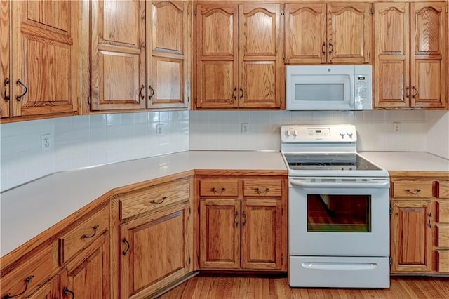 kitchen with white appliances, light hardwood / wood-style floors, and backsplash