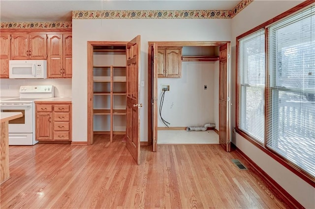 kitchen with white appliances, plenty of natural light, and light wood-type flooring