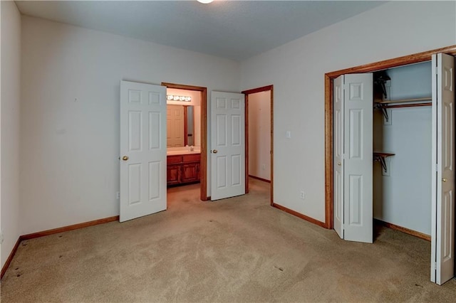 unfurnished bedroom featuring sink, light carpet, and a closet