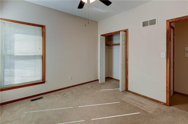 unfurnished bedroom featuring light carpet, ceiling fan, and a closet