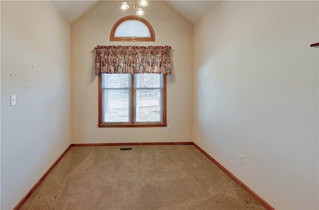 carpeted spare room with lofted ceiling