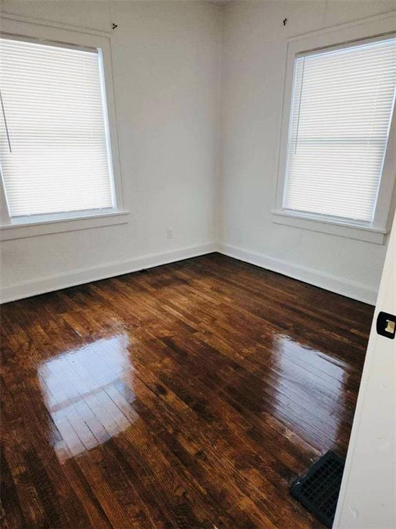 unfurnished room with dark hardwood / wood-style flooring