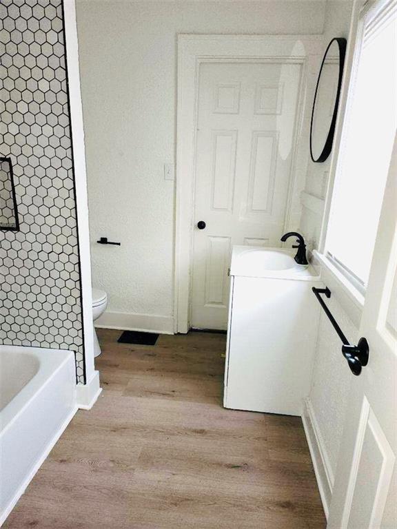 bathroom featuring wood-type flooring, toilet, and vanity