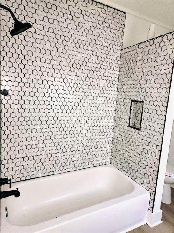 bathroom with tiled shower / bath and toilet