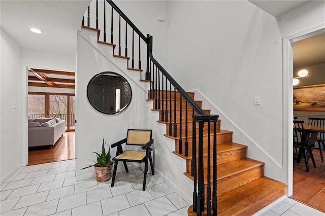 staircase featuring beamed ceiling, tile patterned floors, and coffered ceiling