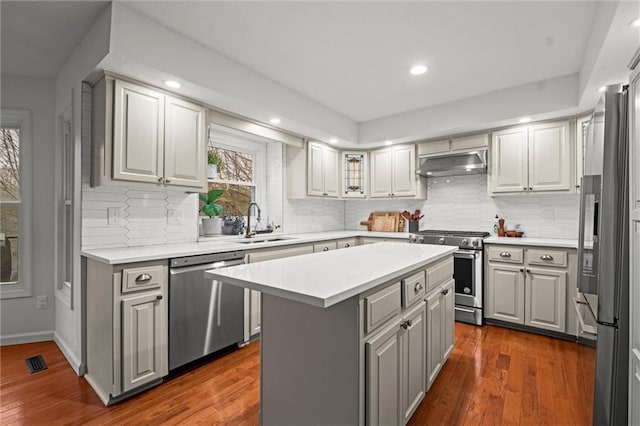 kitchen featuring dark wood-type flooring, sink, gray cabinetry, a kitchen island, and stainless steel appliances