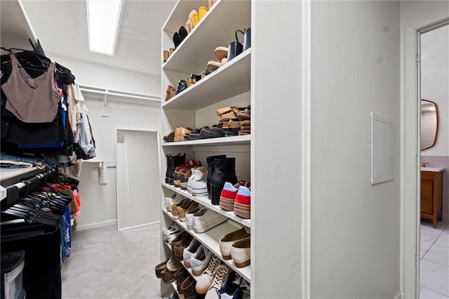 walk in closet featuring light colored carpet