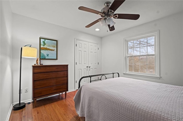 bedroom with a closet, ceiling fan, and light wood-type flooring