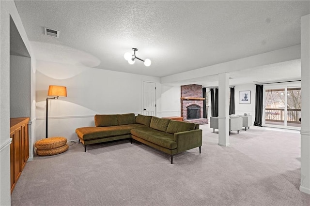 carpeted living room with a fireplace and a textured ceiling