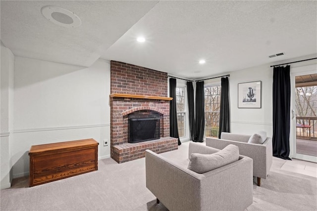 living room featuring light carpet, a brick fireplace, and a textured ceiling