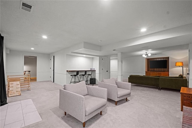 carpeted living room featuring bar area