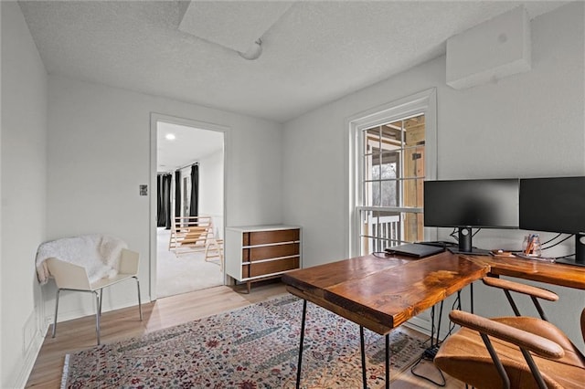 office space with light hardwood / wood-style floors and a textured ceiling