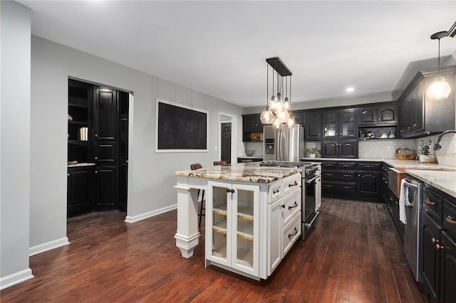 kitchen featuring pendant lighting, dark wood-type flooring, a center island, and appliances with stainless steel finishes