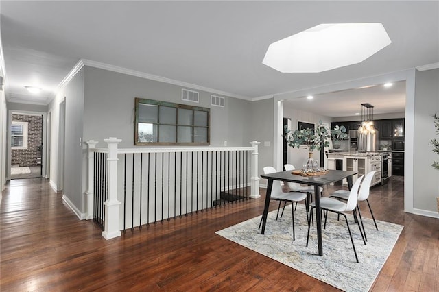 dining room with ornamental molding, dark hardwood / wood-style flooring, and a skylight