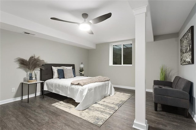 bedroom with dark wood-type flooring, decorative columns, and ceiling fan