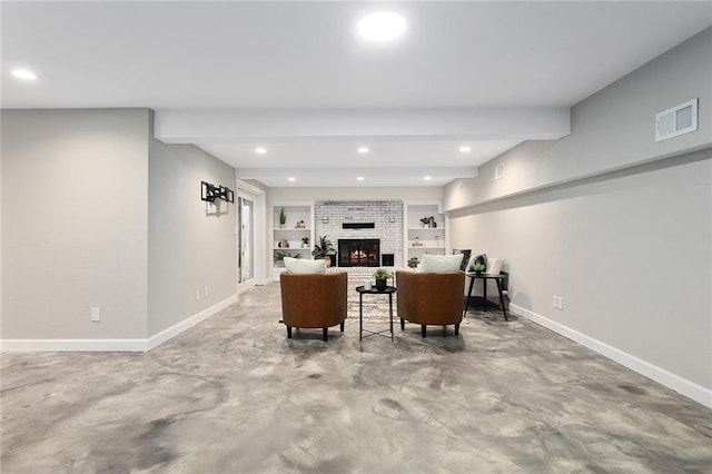 living room featuring beam ceiling, concrete floors, a fireplace, and built in shelves