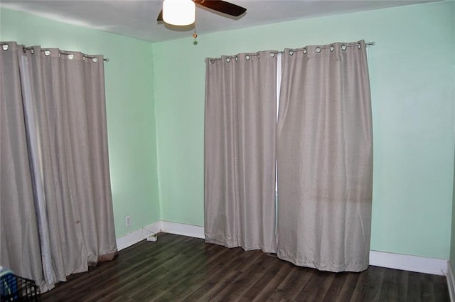 empty room featuring dark hardwood / wood-style flooring and ceiling fan