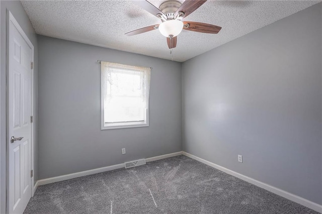 empty room with a textured ceiling, ceiling fan, carpet, and baseboards