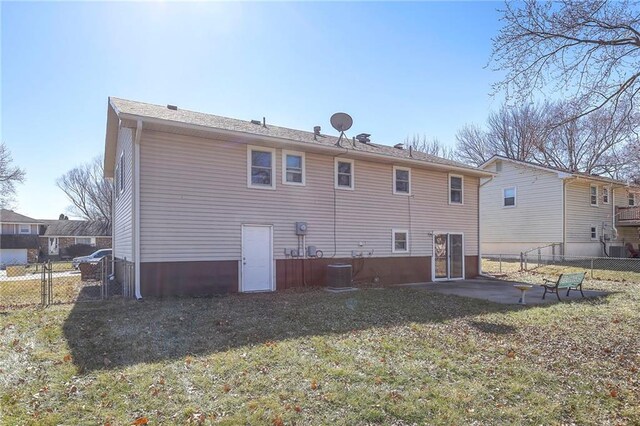 rear view of property featuring a lawn, a gate, fence, cooling unit, and a patio area