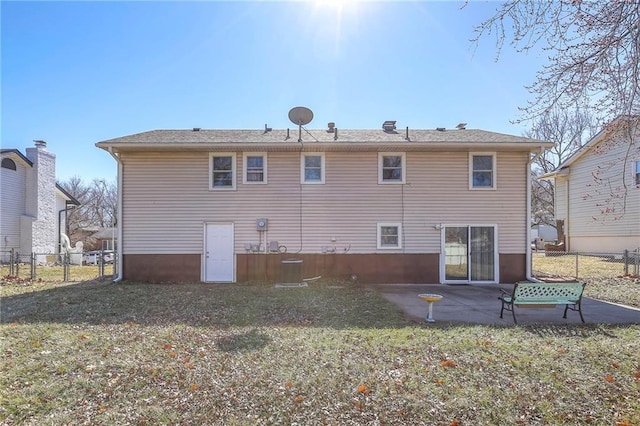 rear view of house featuring a patio, a yard, and fence