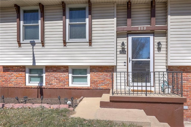 entrance to property featuring brick siding