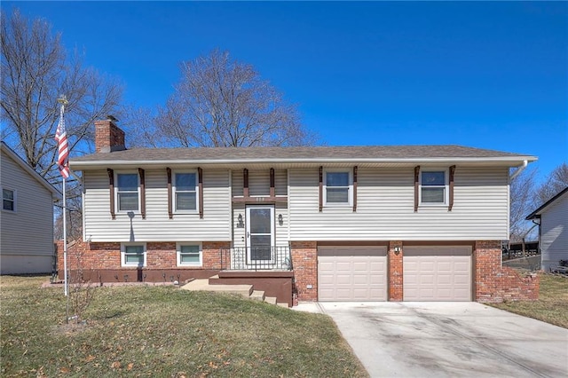 bi-level home with driveway, brick siding, a chimney, and a front lawn