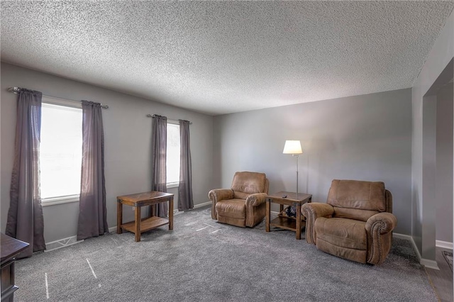 sitting room featuring carpet flooring, a textured ceiling, and baseboards