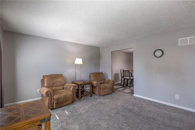 sitting room featuring a textured ceiling, visible vents, and baseboards