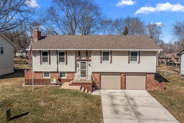 split foyer home featuring driveway, a chimney, a front lawn, and brick siding