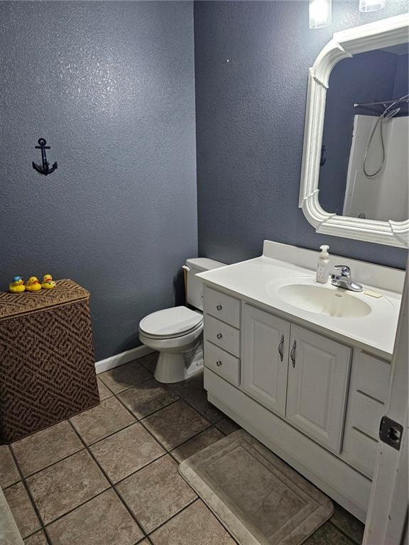 bathroom with vanity, tile patterned flooring, and toilet