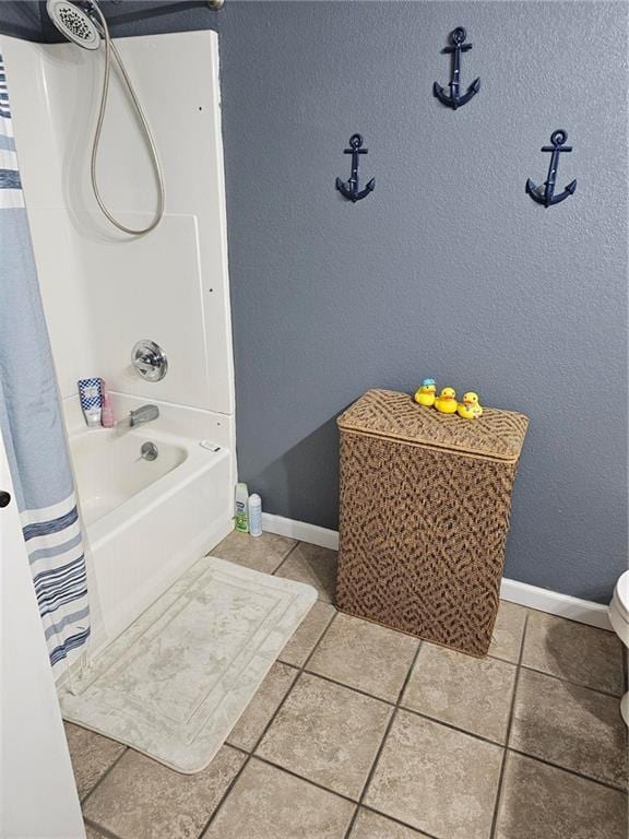 bathroom with tile patterned flooring, shower / tub combo, and toilet