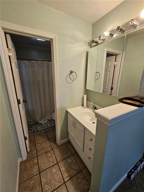 bathroom with a shower with curtain, tile patterned floors, vanity, and toilet