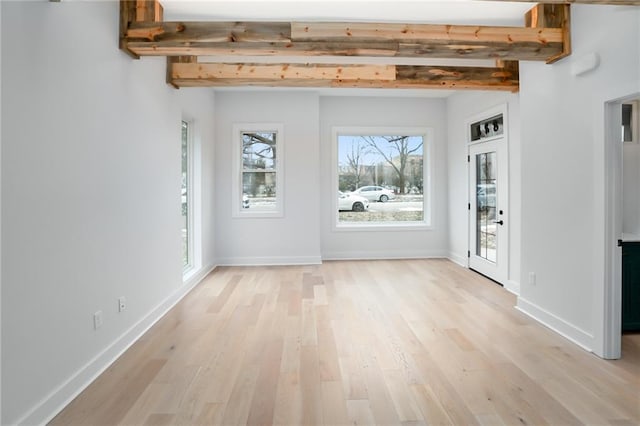 entryway with baseboards, beamed ceiling, and light wood-style floors