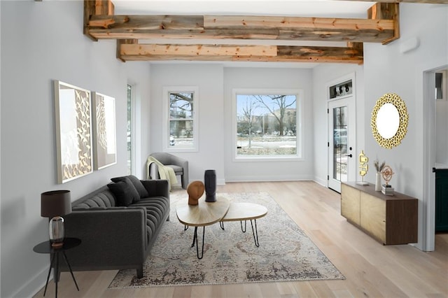 sitting room with light wood finished floors, beam ceiling, and baseboards