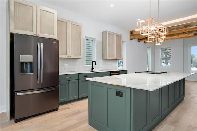 kitchen with stainless steel fridge, a center island, light brown cabinets, green cabinets, and a sink