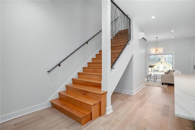 stairway with a wall mounted AC, recessed lighting, wood finished floors, and an inviting chandelier