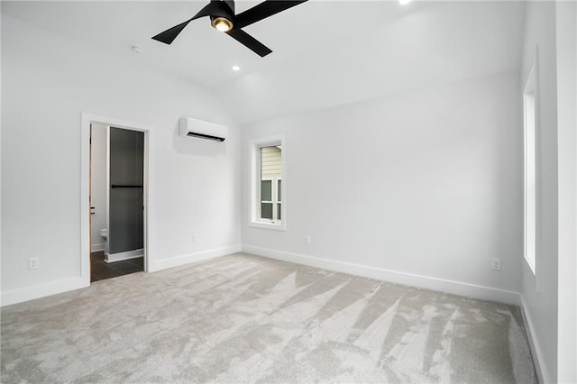 unfurnished bedroom featuring lofted ceiling, recessed lighting, an AC wall unit, light carpet, and baseboards