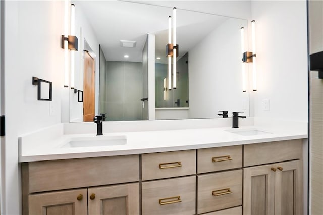 bathroom featuring double vanity, a stall shower, and a sink