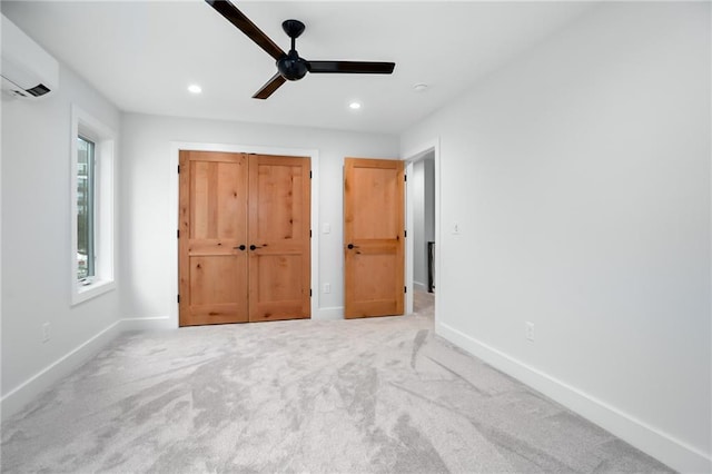 unfurnished bedroom with recessed lighting, an AC wall unit, and baseboards