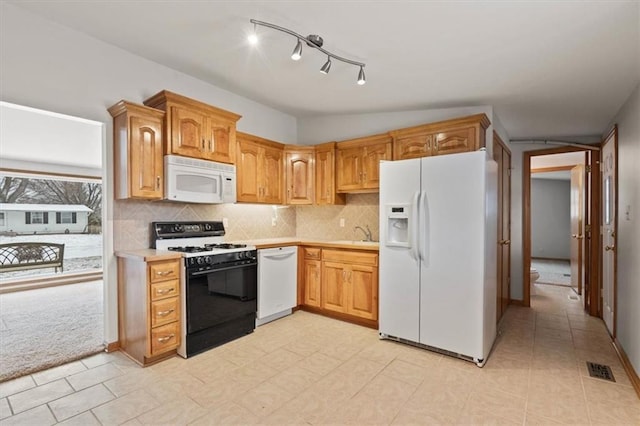 kitchen with sink, backsplash, white appliances, and light colored carpet