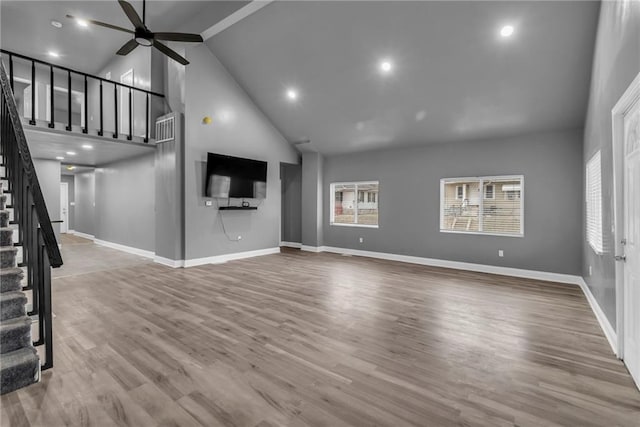 unfurnished living room with wood-type flooring, high vaulted ceiling, and ceiling fan