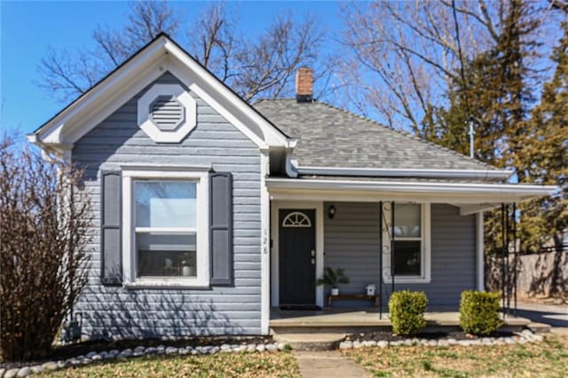 view of front of home with covered porch and a chimney