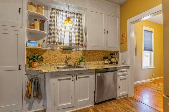 kitchen with dishwasher, white cabinets, and a sink