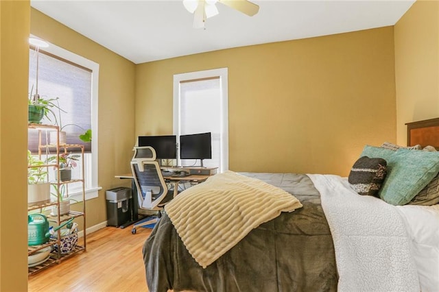 bedroom featuring light wood finished floors, ceiling fan, and baseboards