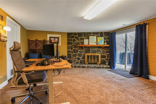 carpeted office space featuring visible vents, a textured ceiling, and a fireplace