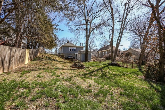 view of yard featuring an outdoor structure and fence