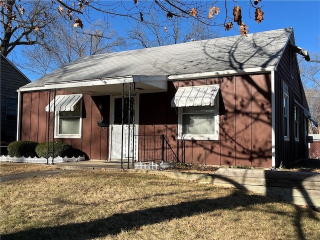 view of home's exterior with roof with shingles, board and batten siding, and a yard