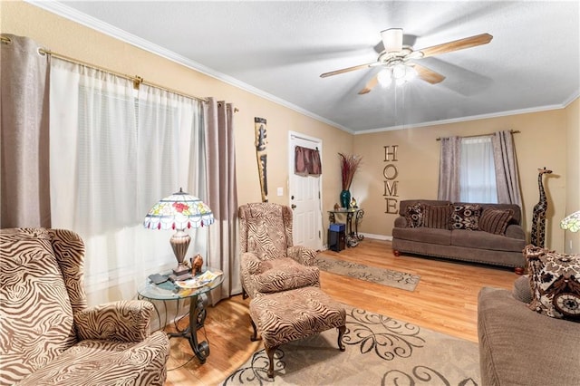 living area with ceiling fan, wood finished floors, and ornamental molding